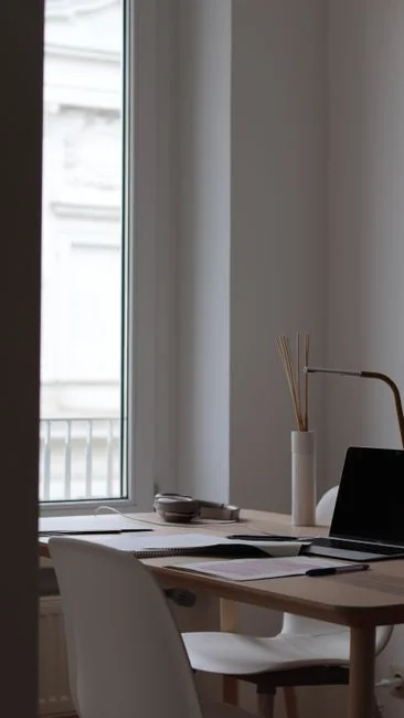 A clean and organized home office desk with a cleaner bottle and sponge, emphasizing simplicity and functionality.